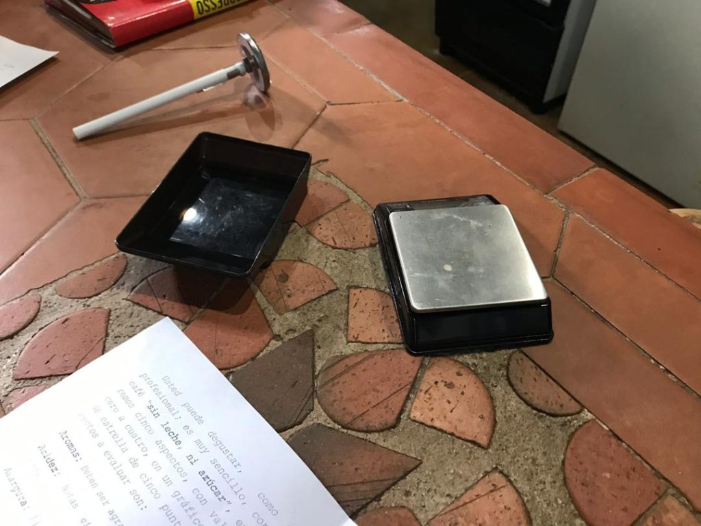 Los baristas utilizan diversos accesorios y herramientas para preparar sus cafés, en la foto una pequeña balanza digital y un termómetro.